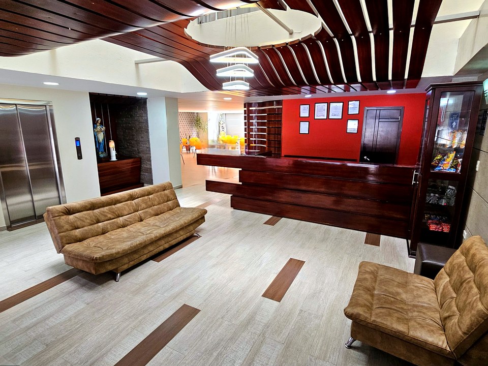 Recepción del Hotel Avanty con mostrador rojo y sala de espera