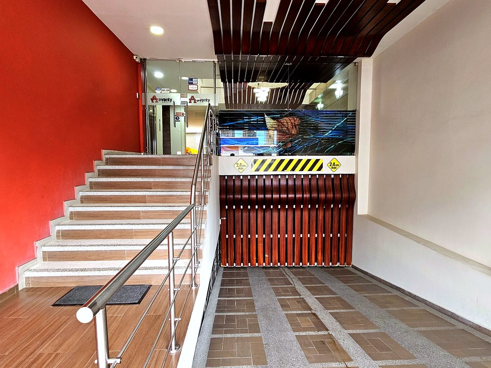 Escaleras y acceso interior del Hotel Avanty con pared roja