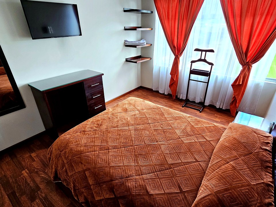 Habitación sencilla del Hotel Avanty con escritorio, TV y vista a la montaña